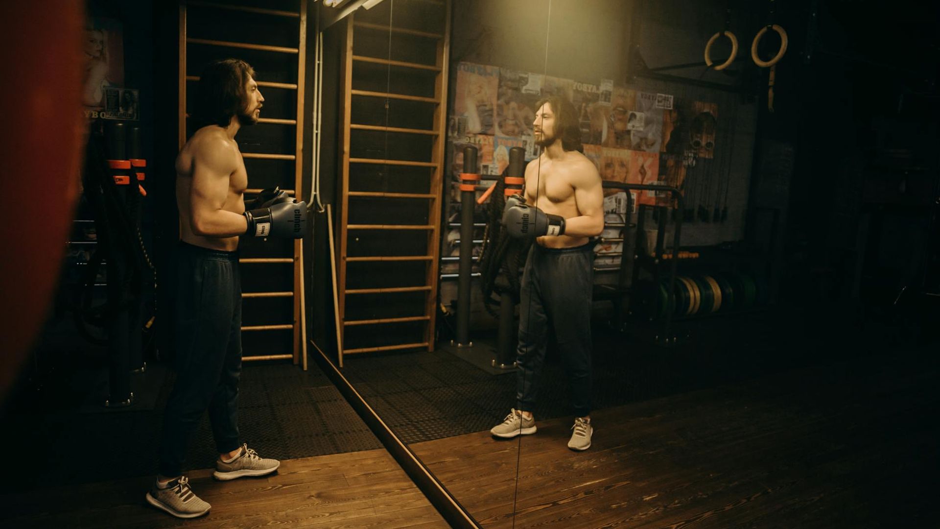 Athlete performing cardio movements in a dark modern gym setting.