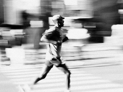 Blurred motion of a runner in a dark urban environment.