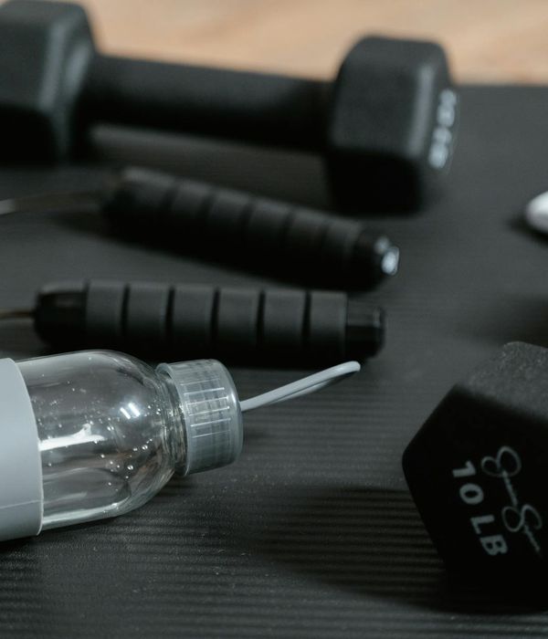 Close up of sports equipment and water bottle in gym.