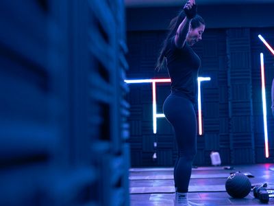 Minimalist fitness studio with blue neon light lines.